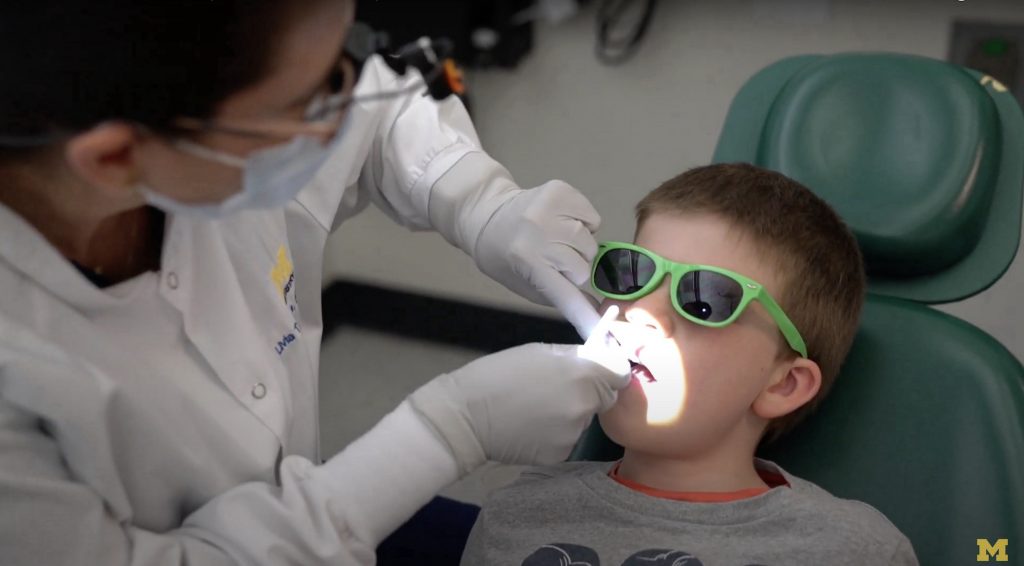 A School of Dentistry faculty member applies SDF to a boy's cavities as part of the clinical trial.